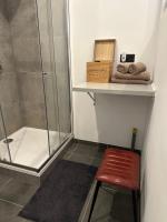 a bathroom with a shower and a red stool at Antwerp West Side in Zwijndrecht
