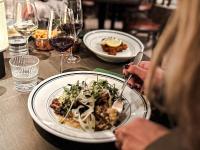 una persona sentada en una mesa con un plato de comida en Clarion Hotel Grand Östersund, en Östersund