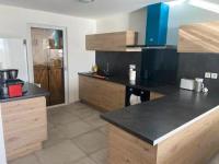 a kitchen with black counter tops and wooden cabinets at Maison de 2 chambres avec vue sur la mer jardin clos et wifi a Sete in Sète