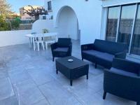 a patio with couches and a table and a table and chairs at Maison de 2 chambres avec vue sur la mer jardin clos et wifi a Sete in Sète