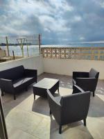 a patio with chairs and tables on a balcony at Maison de 2 chambres avec vue sur la mer jardin clos et wifi a Sete in Sète