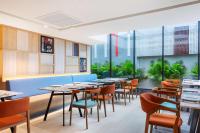 ein Restaurant mit Tischen und Stühlen und großen Fenstern in der Unterkunft Best Western Click Sathorn 11 Bangkok in Bangkok