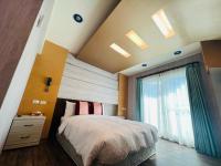 a bedroom with a large bed and a window at Ibizakenting Hotel in Kenting