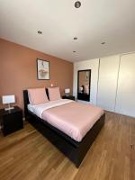 a bedroom with a large bed with pink pillows at Chaleureux T4, à 20 min de Paris in Argenteuil