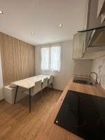 a kitchen with a table and chairs in a room at Chaleureux T4, à 20 min de Paris in Argenteuil
