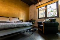 a bedroom with a bed and a chair and a window at Timeout Heritage Hotel Zagreb in Zagreb