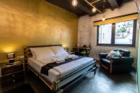 a bedroom with a bed and a chair and a window at Timeout Heritage Hotel Zagreb in Zagreb