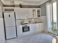 a white kitchen with white cabinets and a refrigerator at ZEN in Marseille