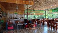 Un restaurante con paredes de madera y mesas y sillas. en Sunny Eco Lodge, en Cát Tiên