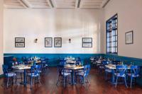 a dining room with tables and blue chairs at JAZ Grand Marsa in Coraya Bay