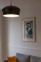 a light hanging over a couch in a living room at Appartement entier au coeur de Nogent Sur Marne in Nogent-sur-Marne
