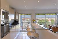 a kitchen with a bar with chairs and a balcony at Le Beauséjour in Cannes