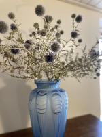 a blue vase with flowers in it on a table at Le Taurillou 