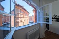 a room with a window with a view of a building at Numéro 6 - Place Nationale - Wifi et Fibre in Montauban