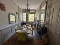 a dining room with a table and chairs and a chandelier at Les 24 colonnes in Lyon