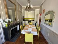 a dining room with a table and yellow chairs at Les 24 colonnes in Lyon