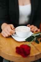 osoba siedząca przy stole z filiżanką kawy w obiekcie Hotel Restaurant Kod Barića w mieście Grude