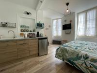 a bedroom with a bed and a kitchen with a sink at Studio de la Poterie in Vermenton