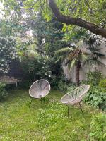 two chairs sitting in the grass in a yard at Maison piscine centre historique de Romainville in Romainville