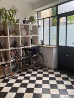 a bike parked in a room with a checkered floor at Maison piscine centre historique de Romainville in Romainville