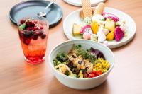 沖縄市にあるREF Okinawa Arena by VESSEL HOTELSのサラダと飲み物と食べ物の皿が置かれたテーブル