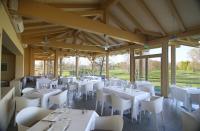 Un comedor con mesas blancas y sillas blancas. en Golf Hotel Cavaglià, en Cavaglià