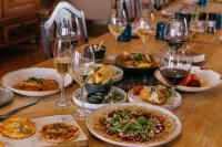 uma mesa com pratos de comida e copos de vinho em Blaauwklippen Manor by NEWMARK em Stellenbosch