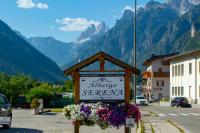 un cartel en una calle con montañas en el fondo en Hotel Serena - Tre Cime Views, en Auronzo di Cadore