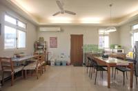 a kitchen with tables and chairs and a ceiling fan at Happy Tree Hostel in Jinning