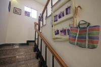 a hallway with stairs and bags on the wall at Happy Tree Hostel in Jinning