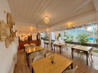 um restaurante com mesas e cadeiras de madeira e janelas em Anlio Resort em Dauis