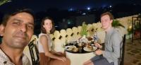 twee mannen en een vrouw aan een tafel met een bord eten bij Rajputana Heritage in Sawāi Mādhopur