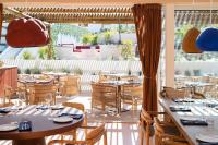 a restaurant with tables and chairs and a large window at Independente Comporta in Comporta