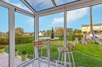 a glass conservatory with a table and two chairs at Meublé De Tourisme Acanthe in Camaret-sur-Mer