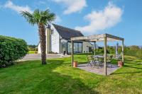 a patio with a table and a palm tree at Meublé De Tourisme Acanthe in Camaret-sur-Mer