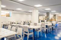 een eetkamer met witte tafels en witte stoelen bij ALEGRIA Sun Village in Lloret de Mar