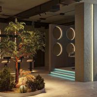 Un vestíbulo con un árbol y espejos redondos en la pared. en Almaty City, en Türkistan