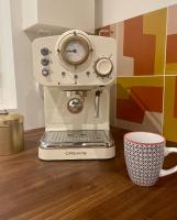 a coffee machine sitting next to a coffee cup at Studio Calme Batignolles in Paris