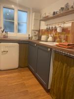 a kitchen with a sink and a refrigerator at Studio Calme Batignolles in Paris