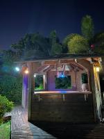 a wooden cabin with a lit up window at night at Appartement Coeur de Papillon in Baie-Mahault