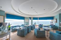 a restaurant with blue chairs and tables and the ocean at Awashima Hotel in Numazu