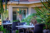 two tables and chairs on a patio with plants at Best Western Premier Hotel Prince de Galles in Menton