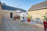 a patio with a table and chairs and an umbrella at Ar Mimoza - Appt pour 6 in Muzillac