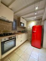 a kitchen with a red refrigerator in a room at Bienvenue au 6 - Calme et charme de la pierre. in Fourques