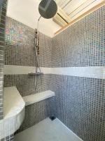 a tiled bathroom with a shower and a bath tub at Bienvenue au 6 - Calme et charme de la pierre. in Fourques