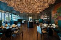 a dining room with tables and chairs and a chandelier at Renaissance Nanning Hotel in Nanning