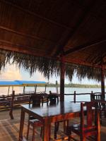 a wooden table with chairs and a view of the ocean at HƯNG THÀNH HOME in Ben Tre