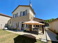 a patio with an umbrella in front of a house at Le LOUIS 16 - Maison avec jardin in Valence