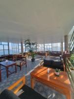 Habitación grande con mesas, bancos y ventanas. en Dhikidada Resort, en Pokhara