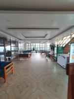 Habitación grande con mesas y bancos en un edificio en Dhikidada Resort, en Pokhara